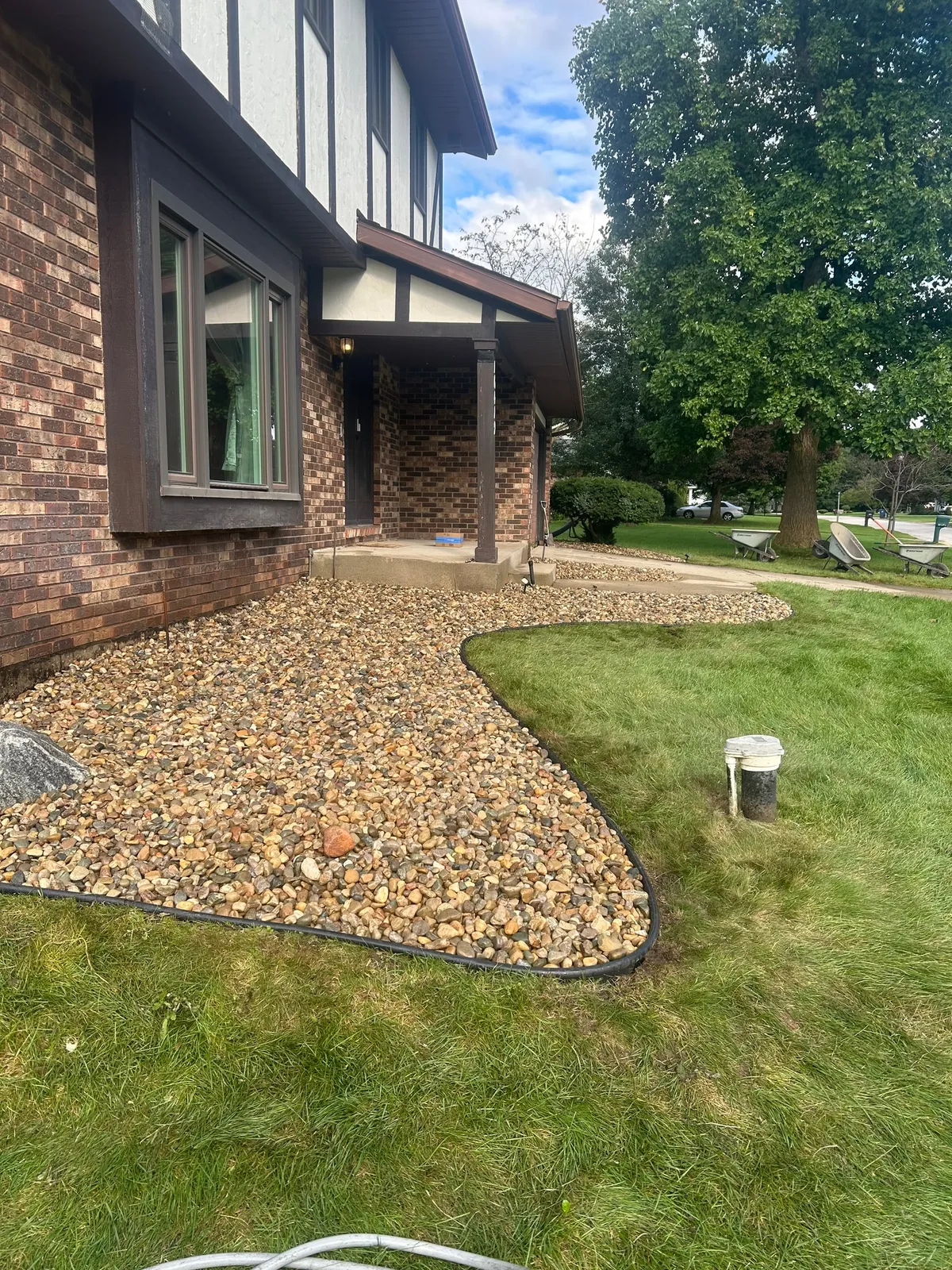 A curved stone bed around a brick entryway