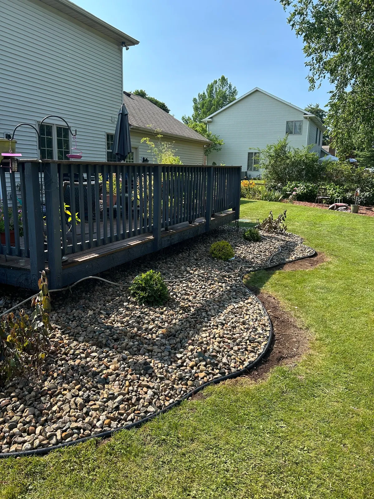 Stone beds and small shrubs along a raised deck