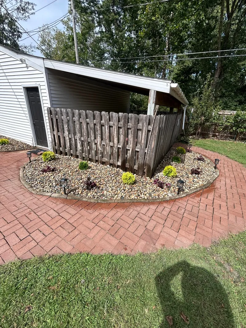 A tidy planted stone bed beside a curved brick path