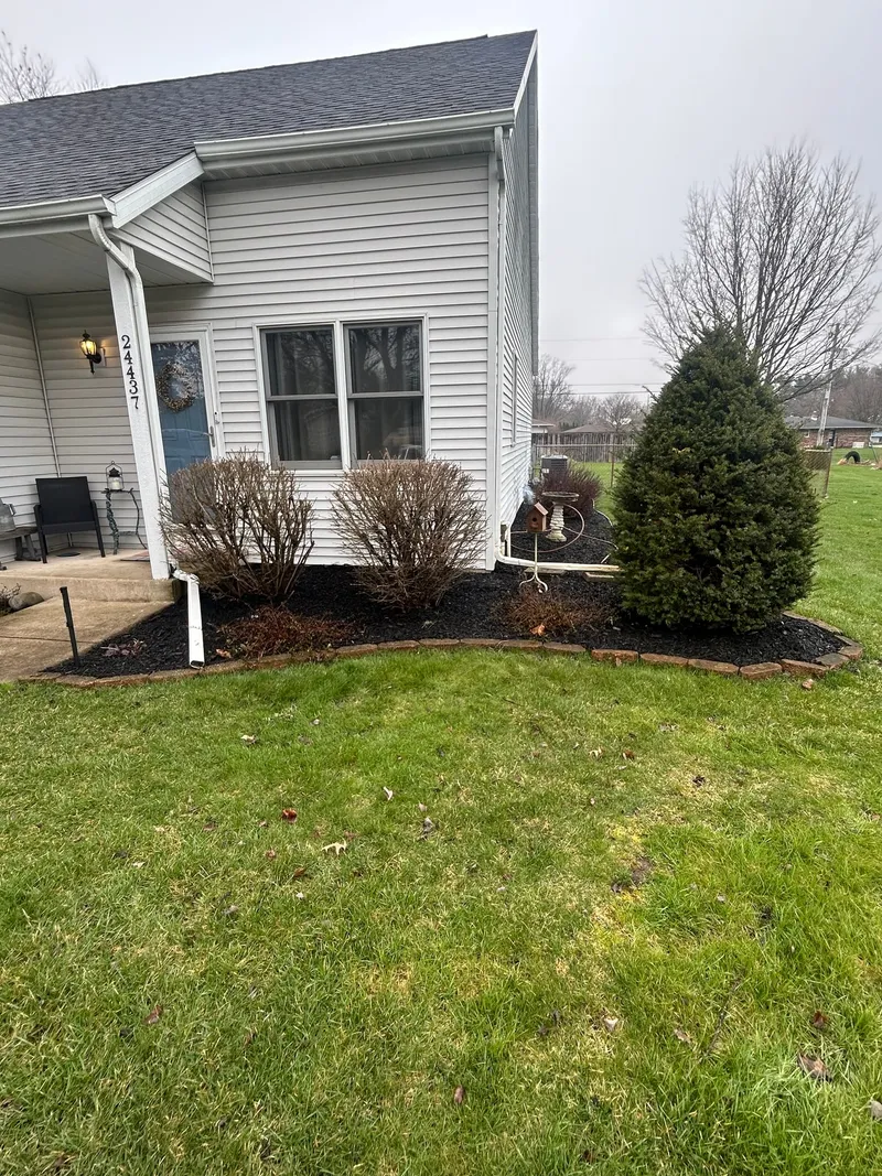 Neat mulch beds and shrubs around a front porch