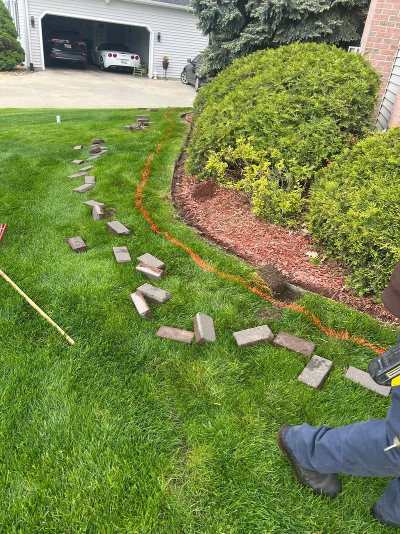 Loose edging stones and a marked bed outline beside rounded shrubs