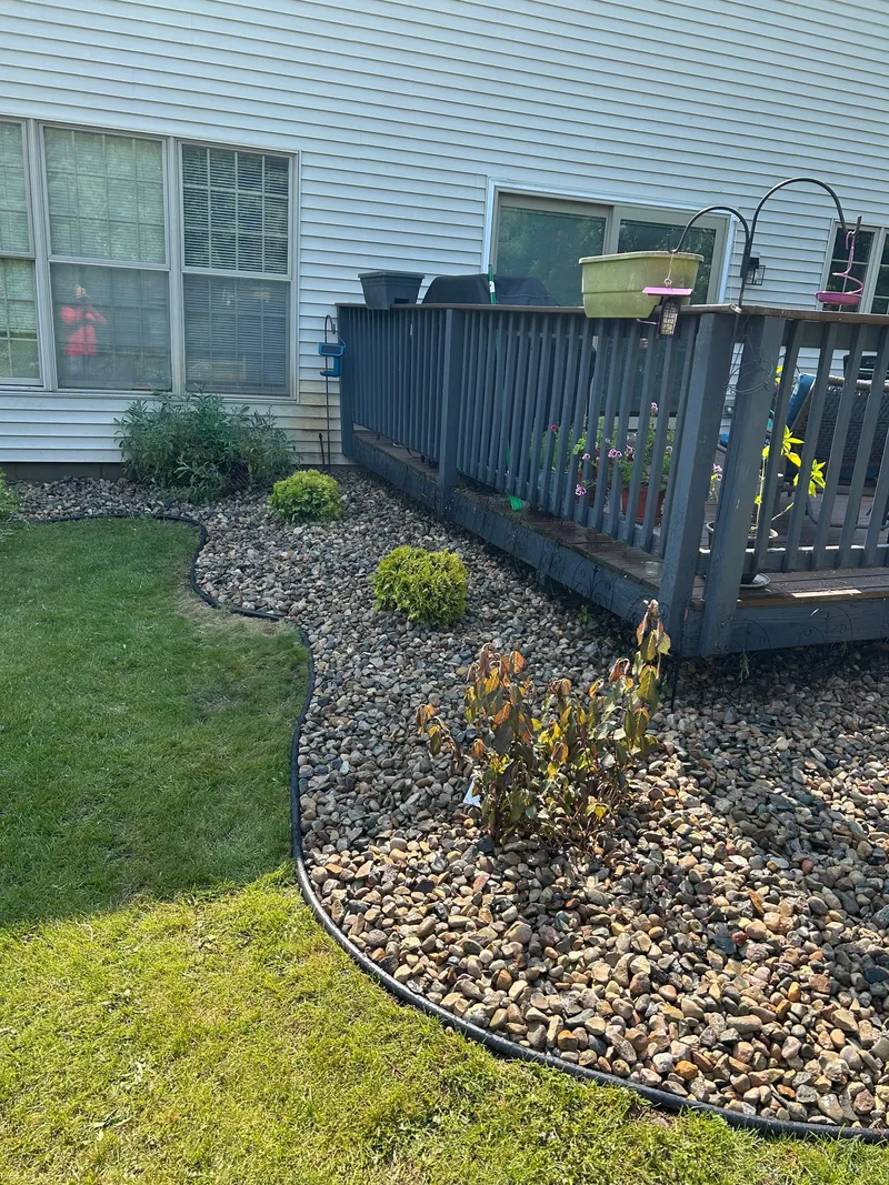 A curved stone border around the corner of a raised deck