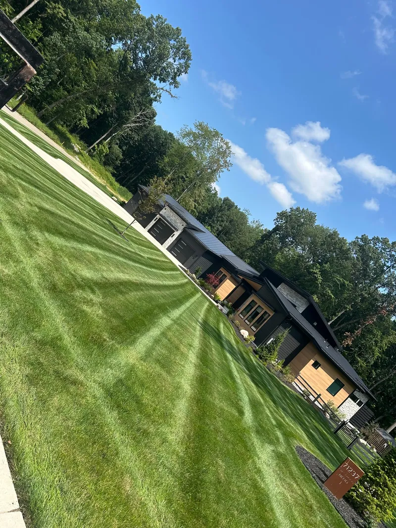 Mowing stripes across a broad lawn, photographed at an angle