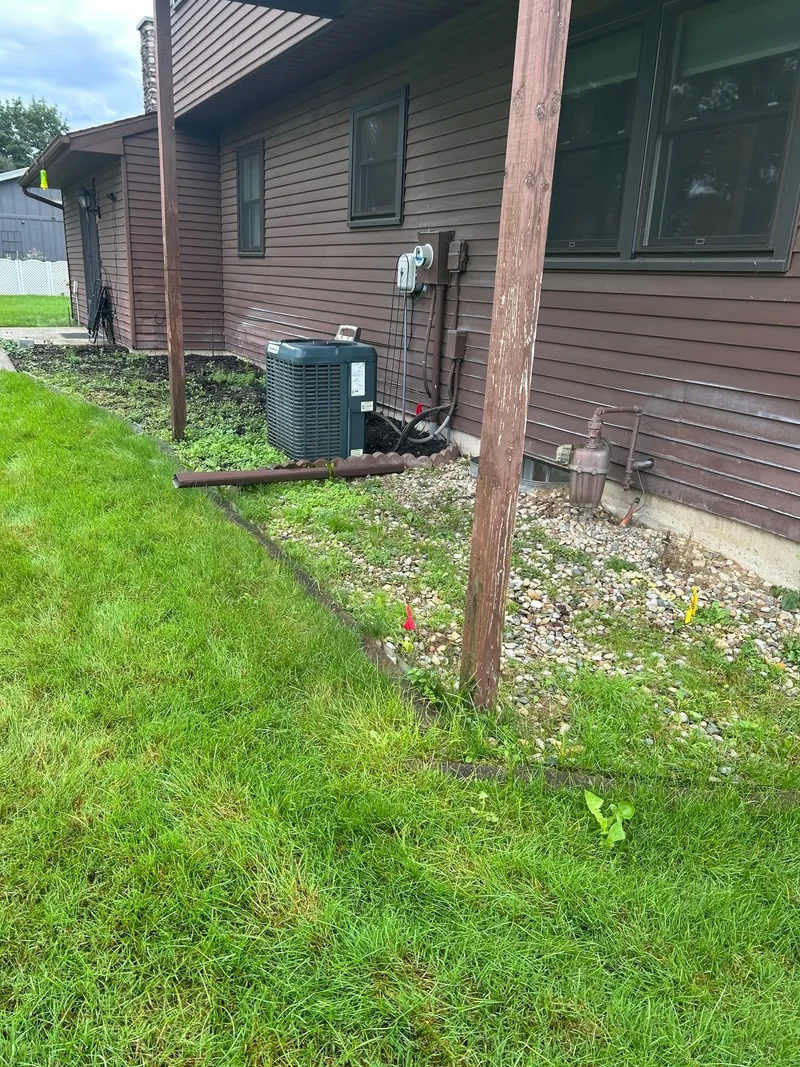 A garden bed along brown house siding during border preparation